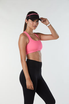 Black tennis visor with pink accents that match pink sports bra for women.